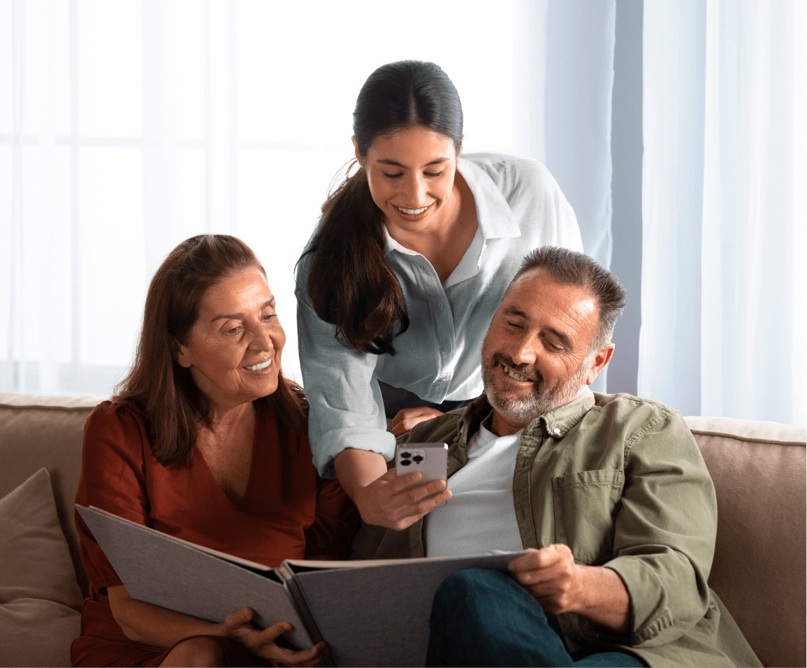 a group of people sitting on a couch looking at a photo album